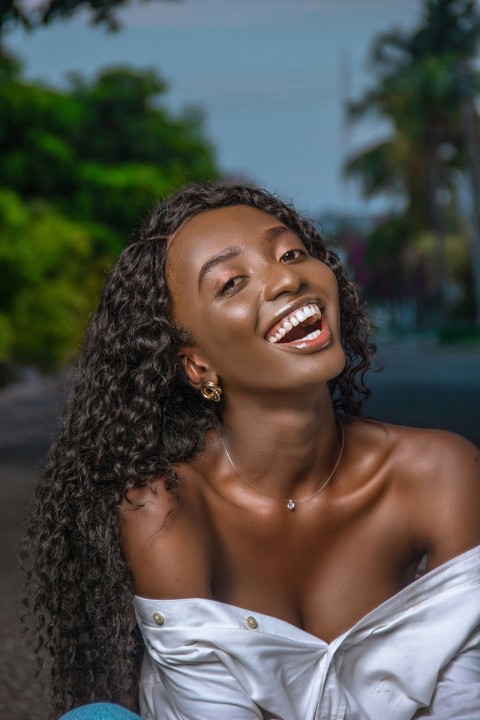 smiling woman in white off shoulder shirt