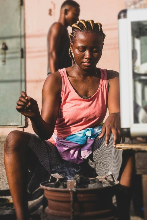 a woman sitting on the ground in front of a truck