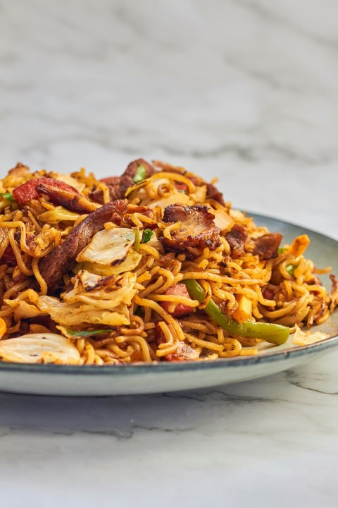 a plate of noodles with meat and vegetables