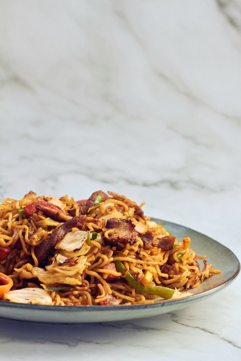 a plate of noodles with meat and vegetables