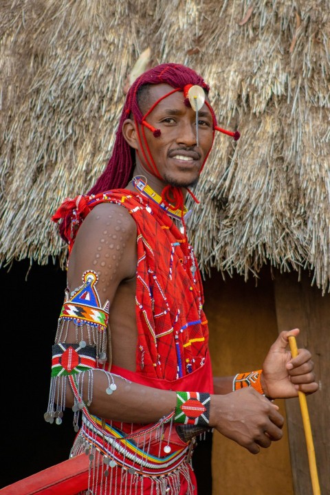 a man in a red outfit holding a stick