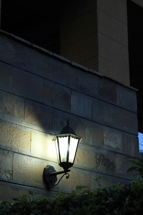 a lamp on the side of a building at night