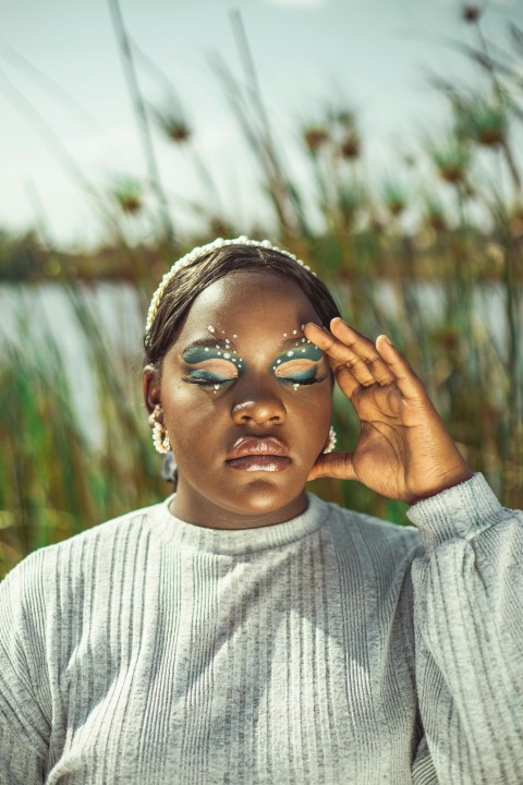 a woman with green eyeshades is posing for a photo