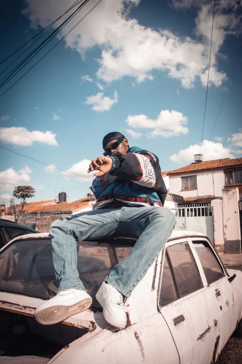 a man sitting on top of an old car