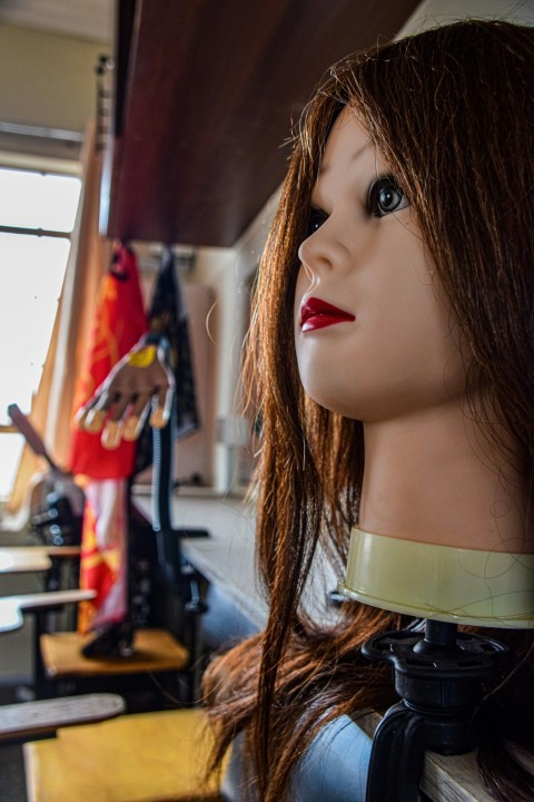 a close up of a mannequins head on a shelf xxn