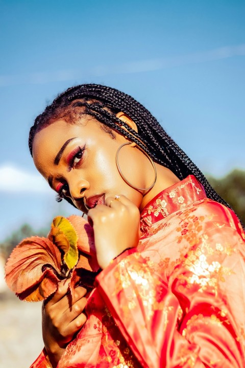 a woman with braids holding a flower in her hand