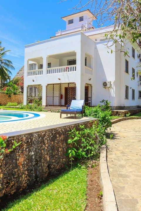 a large white house with a pool in front of it