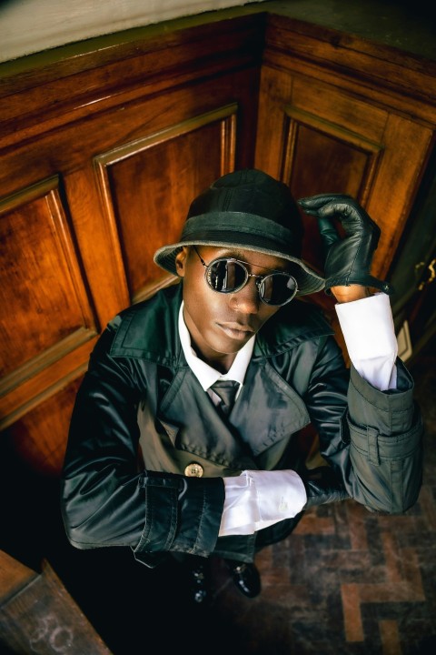 a man in a suit and hat sitting at a table