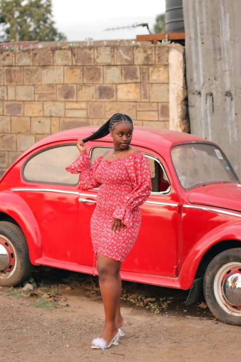 a woman standing next to a red car