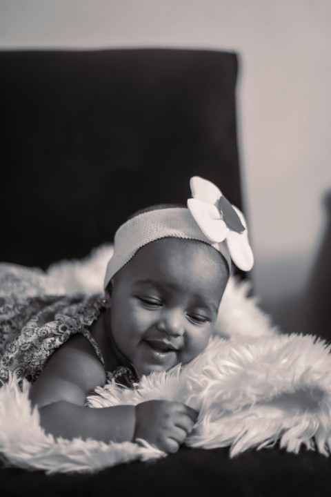 a black and white photo of a baby smiling