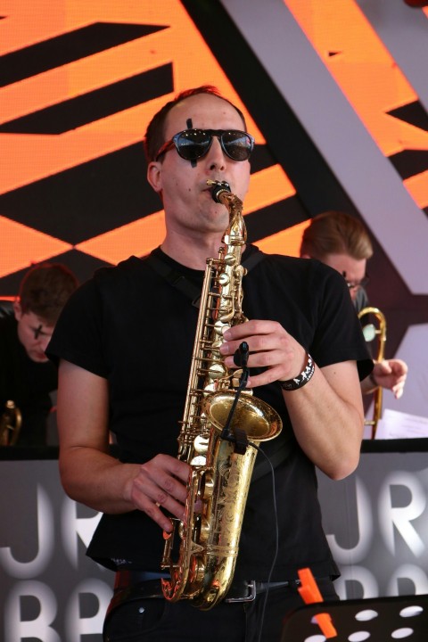 man in black crew neck t shirt using saxophone