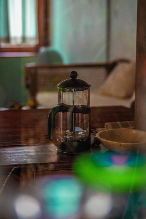 a glass tea kettle on a table