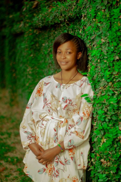 a woman standing in front of a green wall