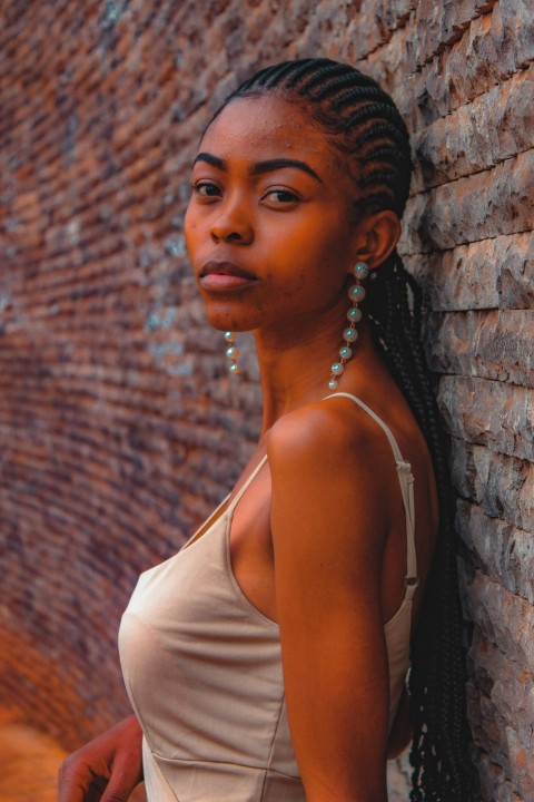 a woman leaning against a brick wall q6_