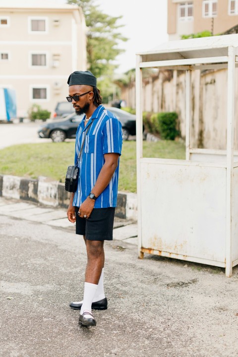 a man in a blue shirt is standing on the street A