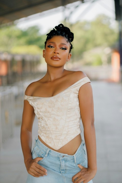 a woman wearing a white top and jeans KMy