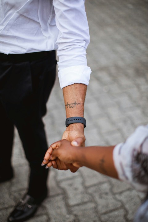 a couple of people holding hands on a street