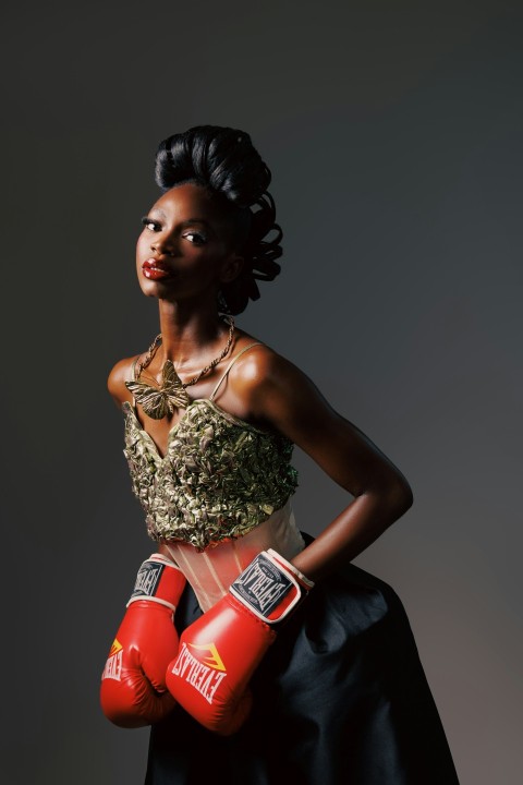 a woman in a dress and red boxing gloves