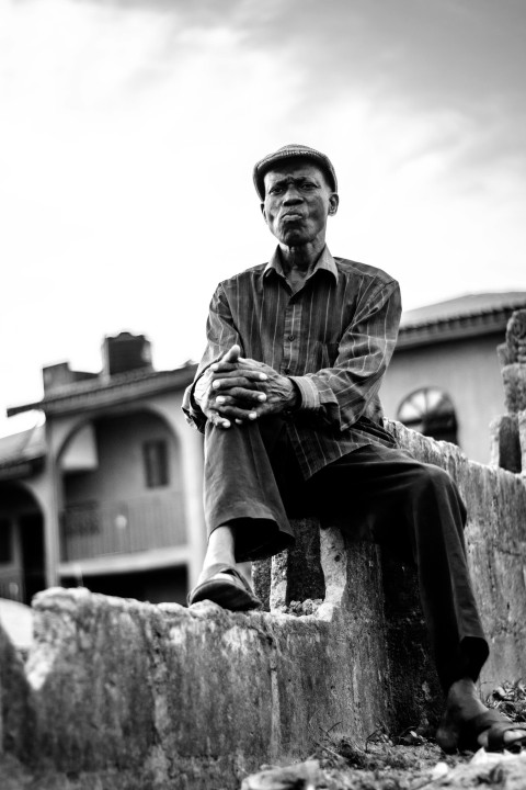 man in button up shirt sitting on concrete bench