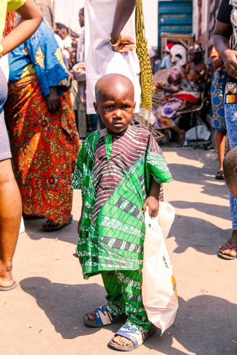 a little boy in a green and red outfit xQccTa8