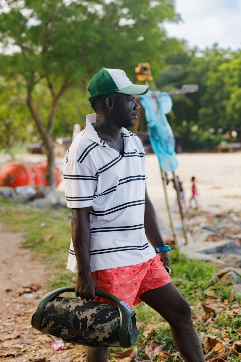 a man with a green hat and red shorts