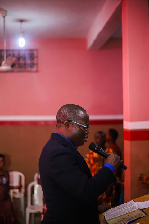 man in black suit holding microphone zUoH