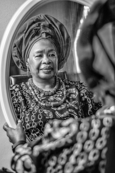 a woman in a turban looking in a mirror