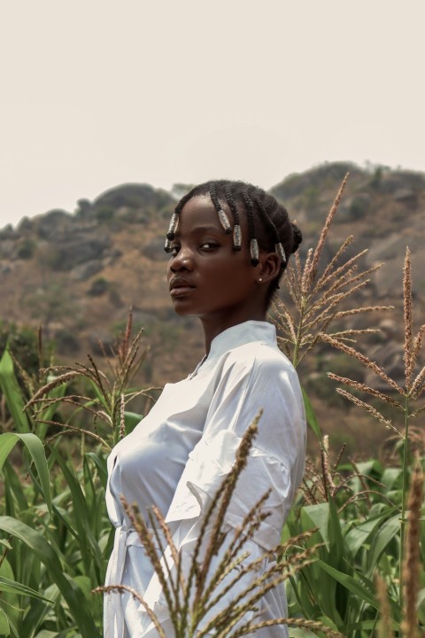 a woman standing in a field of corn I3KMoAu