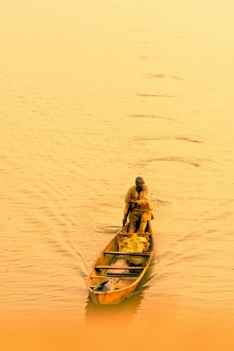 a man sitting in a small boat on a lake B