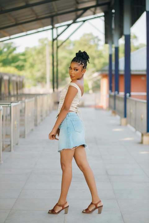 a woman in a white top and blue denim skirt MVm