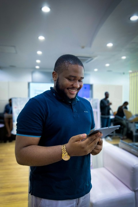 a man standing in a room looking at a tablet