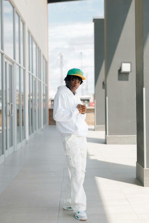 a man in a green hat is walking down a sidewalk