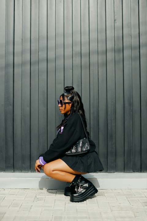 a woman sitting on the ground in a black dress