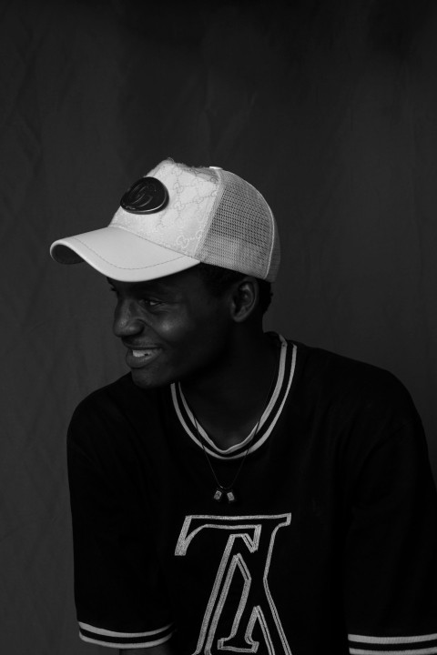 a black and white photo of a man wearing a hat