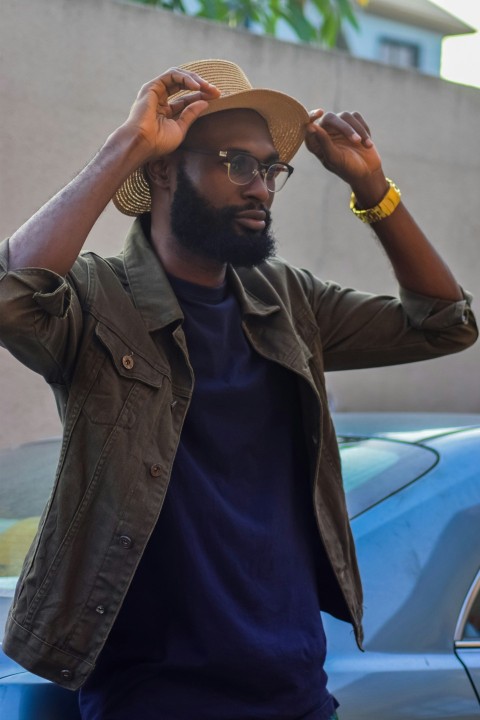 man in black leather jacket wearing brown hat