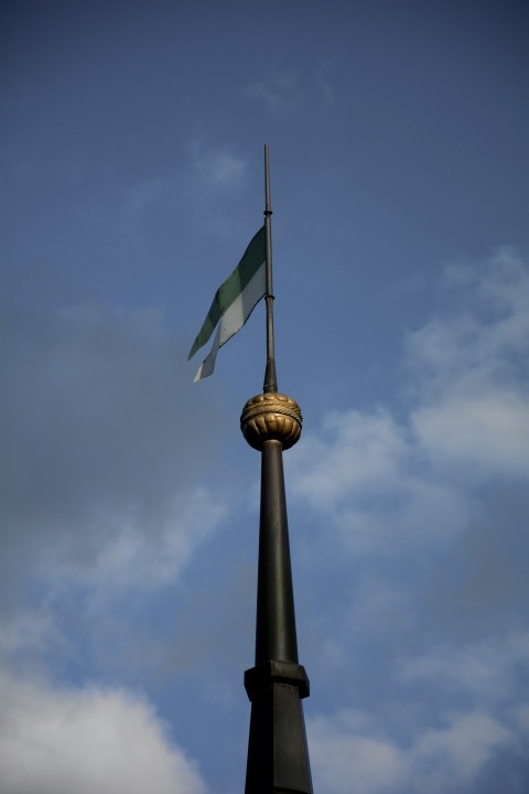 a flag flying on top of a tall tower