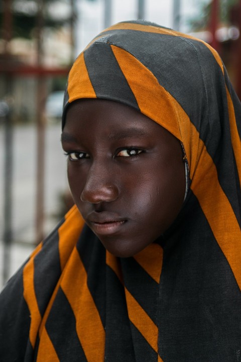 girl in black and orange striped head scarf in selective focus photography