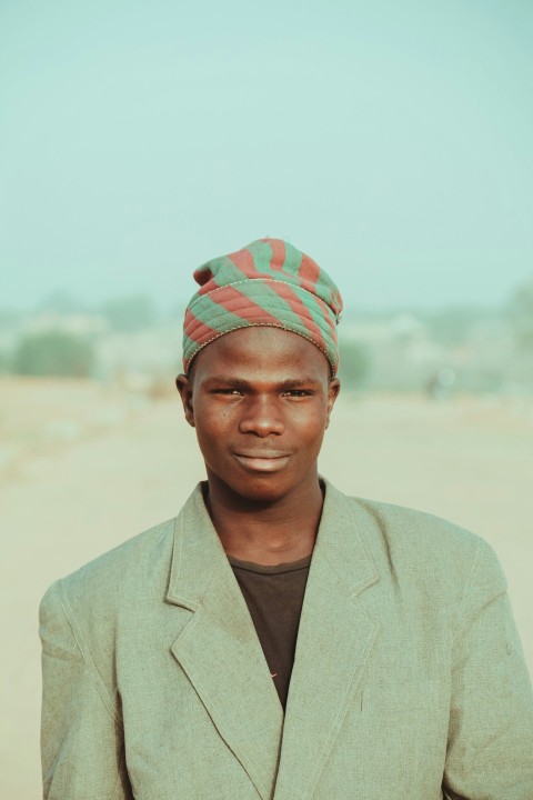 a man wearing a green jacket and a red and green hat