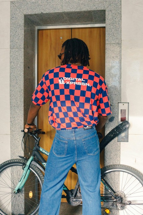 a man standing next to a bike in front of a building