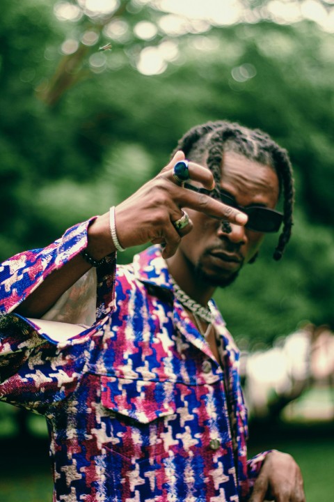 man in blue and red button up shirt holding black sunglasses