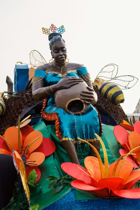 a statue of a woman sitting on top of a float ag0oe6Ilk