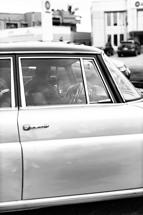 a black and white photo of a car parked on the side of the road