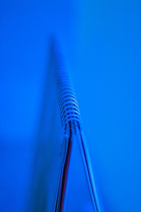 a close up of a toothbrush with a blue background OJN_gT