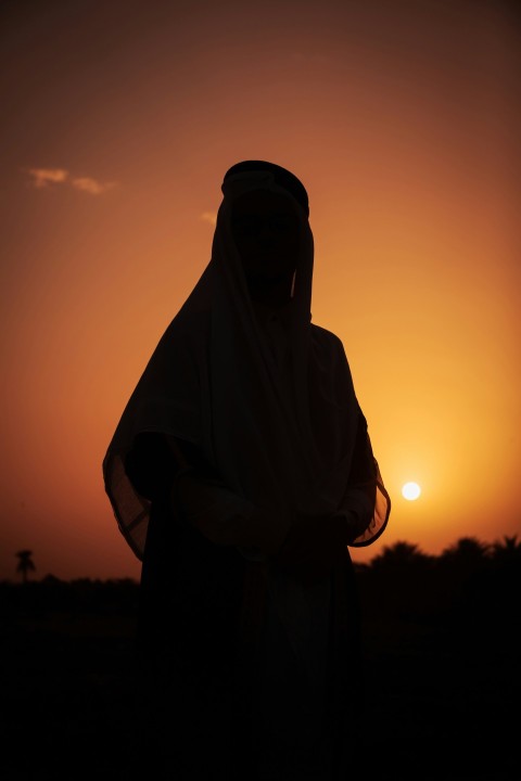 a silhouette of a person wearing a veil at sunset l7Z34