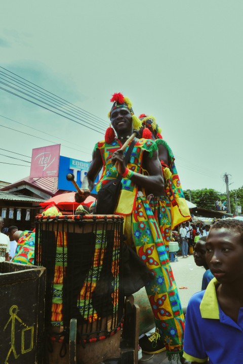 a man in a colorful costume riding on the back of a truck