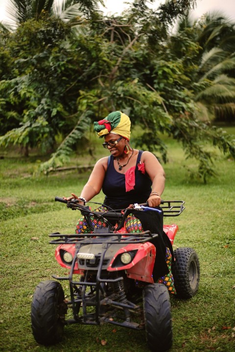 a woman riding on the back of a pink four wheeler Cw0lS0