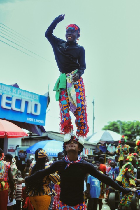 a man standing on top of another man on a street rRnY