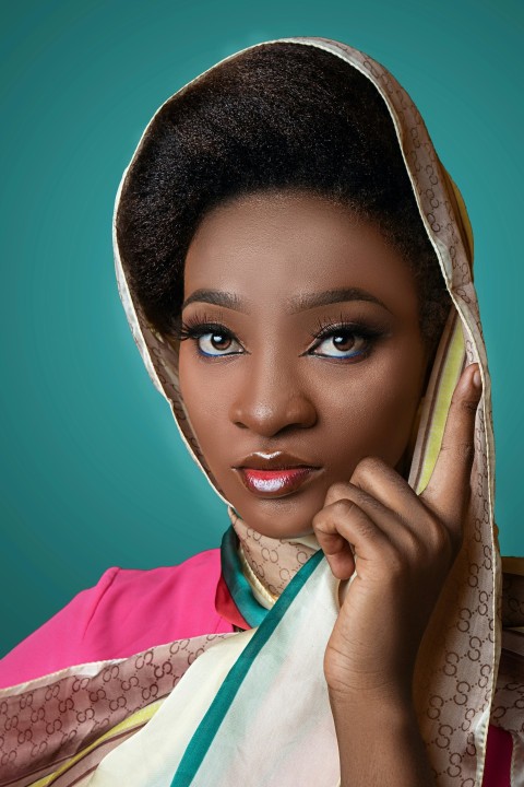 woman in pink shirt covering her face with brown scarf