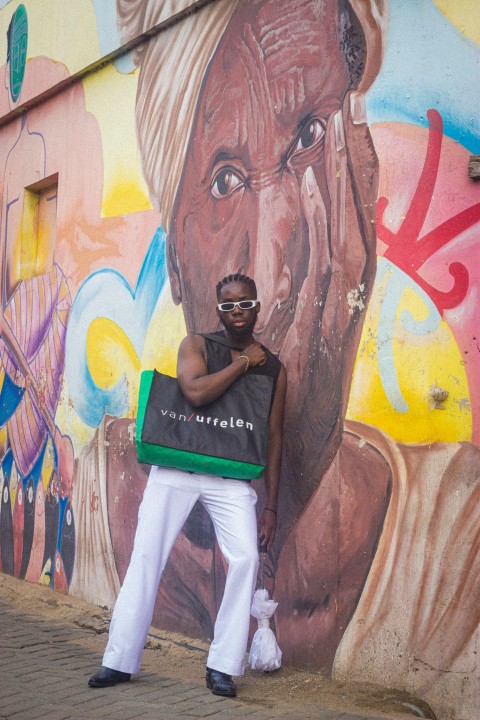 a person posing in front of a wall covered in graffiti