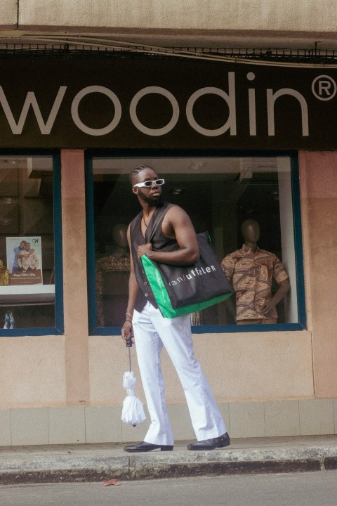 a man wearing a backpack and walking on the sidewalk